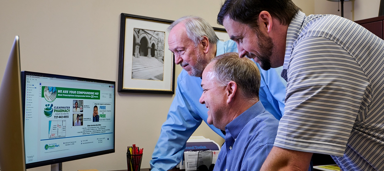Members of the APCI marketing staff review a member project on a computer screen
